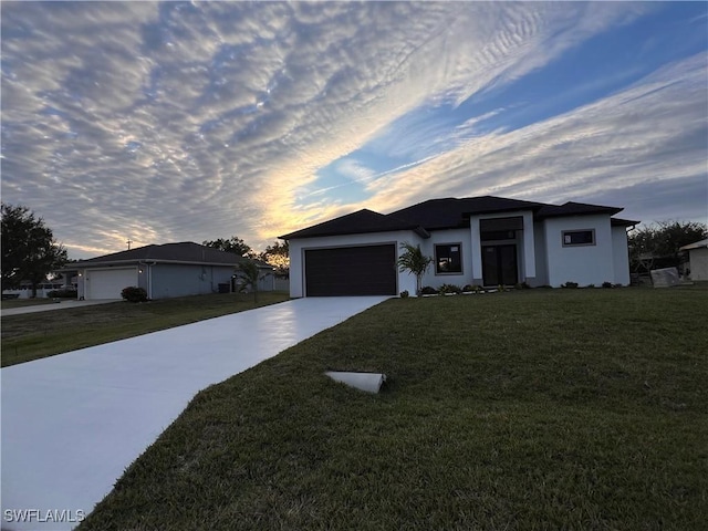 ranch-style house with a garage and a lawn