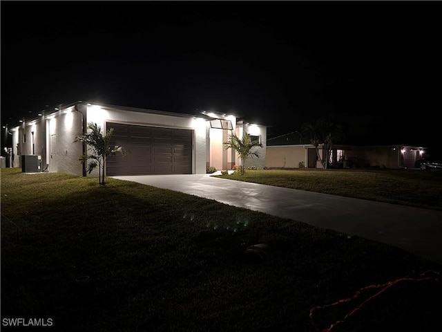 view of front of house with a lawn, a garage, and central AC