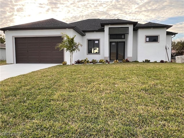 prairie-style home featuring a garage and a front lawn