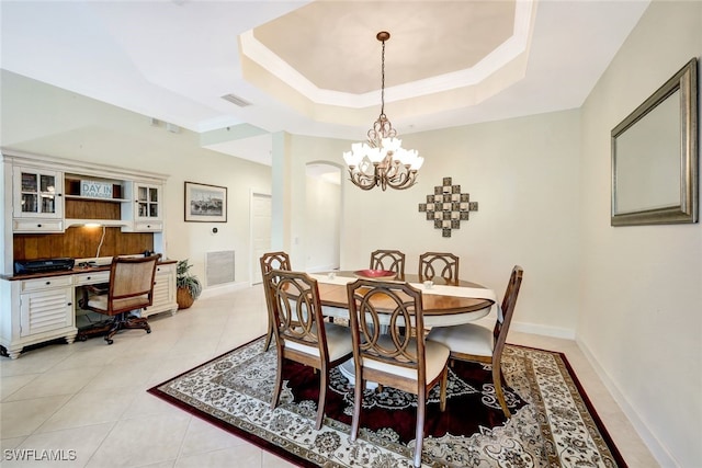 tiled dining area featuring a raised ceiling and an inviting chandelier