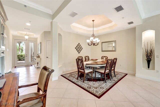 dining space featuring a chandelier, a tray ceiling, ornamental molding, and light tile patterned flooring