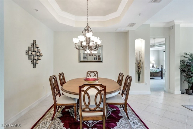 dining area featuring ceiling fan with notable chandelier, a raised ceiling, ornamental molding, and light tile patterned flooring