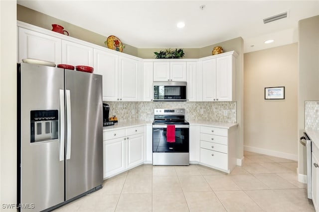 kitchen featuring tasteful backsplash, white cabinets, light tile patterned flooring, and appliances with stainless steel finishes