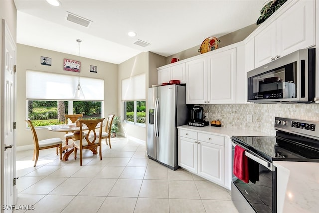 kitchen featuring appliances with stainless steel finishes, tasteful backsplash, white cabinetry, and pendant lighting