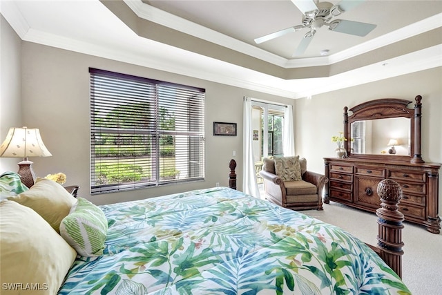 carpeted bedroom featuring a raised ceiling, ceiling fan, and ornamental molding