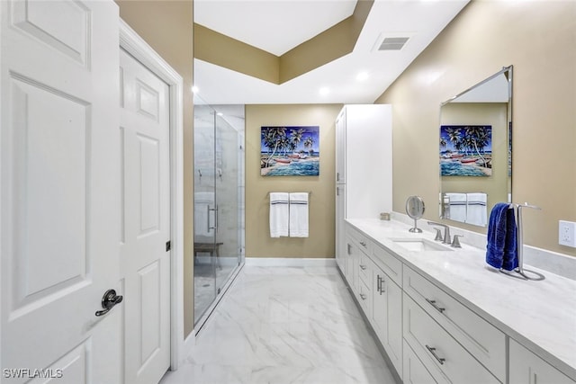 bathroom featuring a shower with door and vanity