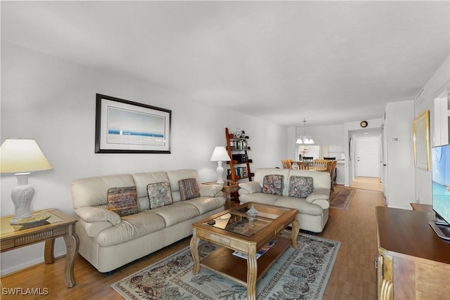 living room featuring an inviting chandelier and light hardwood / wood-style flooring