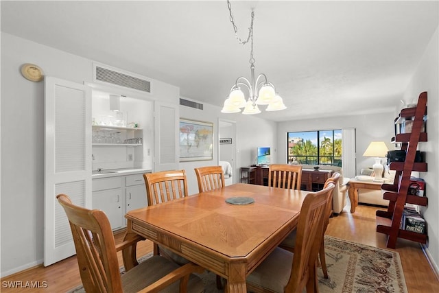 dining area featuring a chandelier and light wood-type flooring