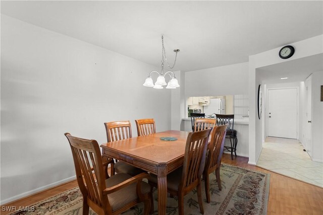 dining room featuring a chandelier and light wood-type flooring