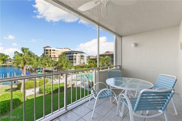 balcony featuring ceiling fan and a water view