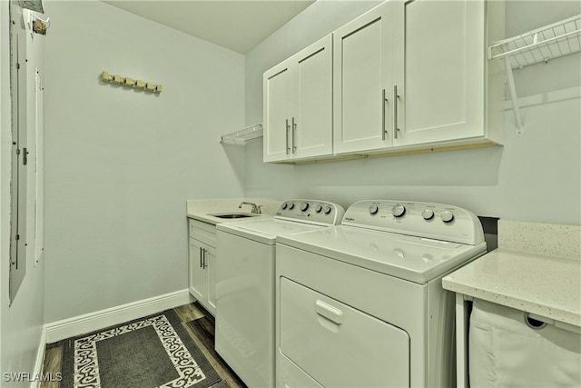 laundry area featuring dark hardwood / wood-style floors, cabinets, sink, and washing machine and clothes dryer