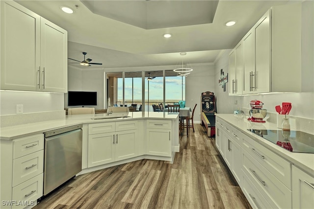 kitchen with hardwood / wood-style floors, black electric stovetop, stainless steel dishwasher, white cabinetry, and kitchen peninsula