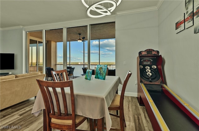 dining room with hardwood / wood-style flooring, ceiling fan with notable chandelier, and ornamental molding