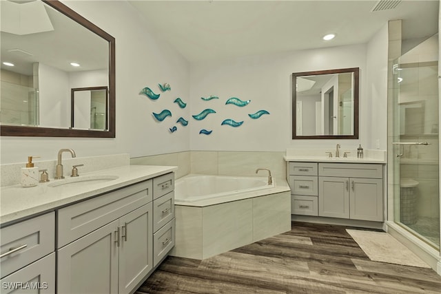 bathroom featuring hardwood / wood-style floors, vanity, and separate shower and tub