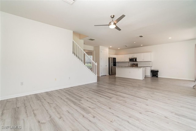 unfurnished living room with ceiling fan and light hardwood / wood-style flooring