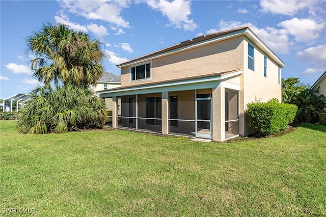 rear view of property featuring a lawn and a sunroom