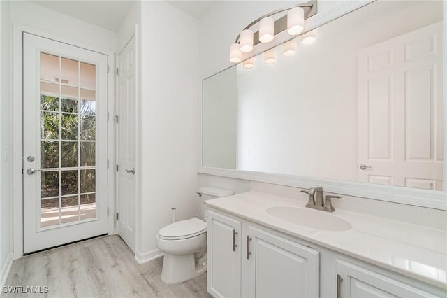 bathroom with hardwood / wood-style flooring, vanity, and toilet