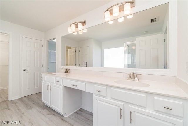 bathroom featuring vanity, wood-type flooring, and an enclosed shower