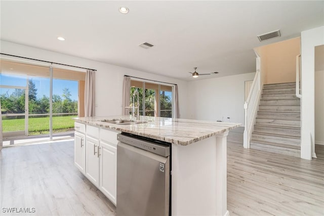 kitchen with a center island with sink, sink, stainless steel dishwasher, light wood-type flooring, and white cabinetry