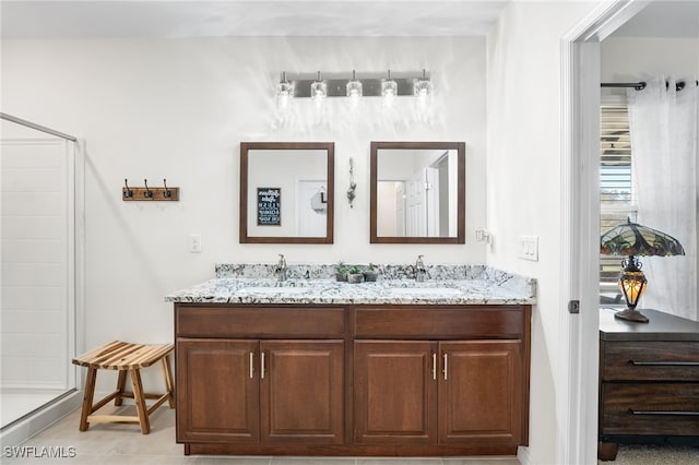 bathroom featuring tile patterned flooring, vanity, and walk in shower