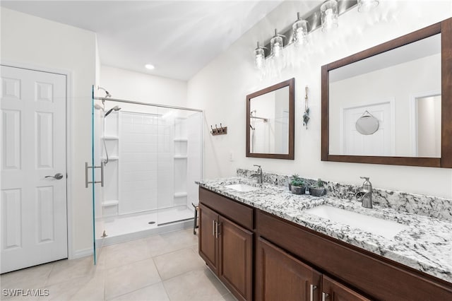 bathroom with tile patterned floors, a shower with door, and vanity