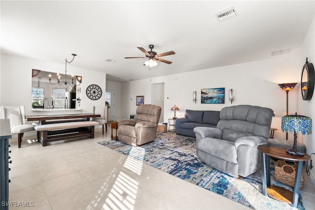 tiled living room with ceiling fan with notable chandelier and sink