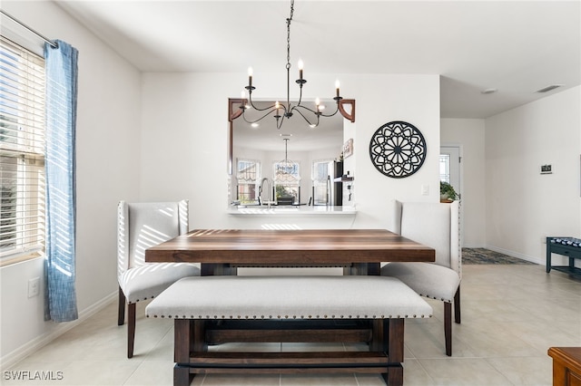 tiled dining area with a notable chandelier, a healthy amount of sunlight, and sink