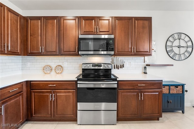 kitchen with tasteful backsplash, light tile patterned flooring, and stainless steel appliances