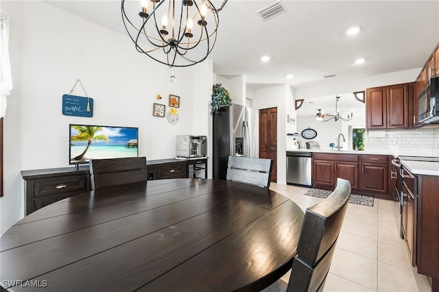 dining space featuring sink, light tile patterned floors, and a notable chandelier