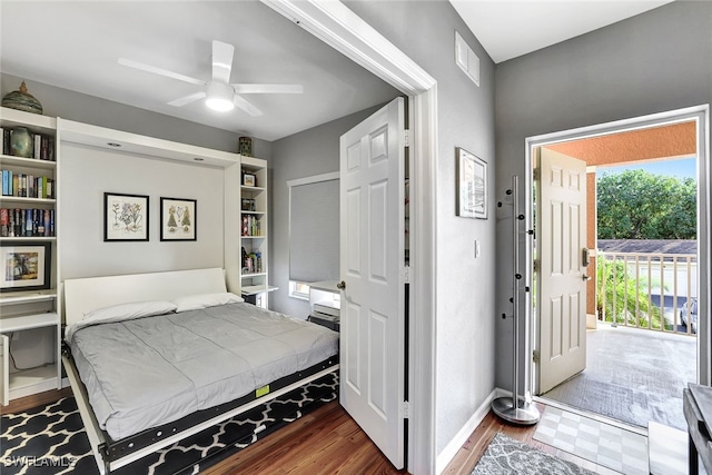 bedroom featuring dark wood-style flooring, a ceiling fan, baseboards, visible vents, and access to exterior