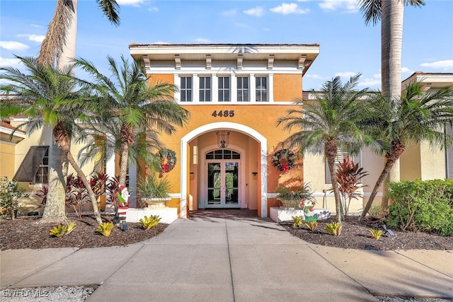 doorway to property featuring french doors and stucco siding