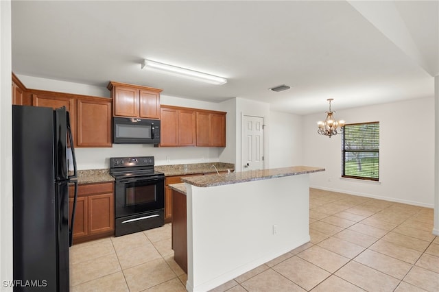 kitchen with light stone countertops, a center island, a notable chandelier, light tile patterned floors, and black appliances