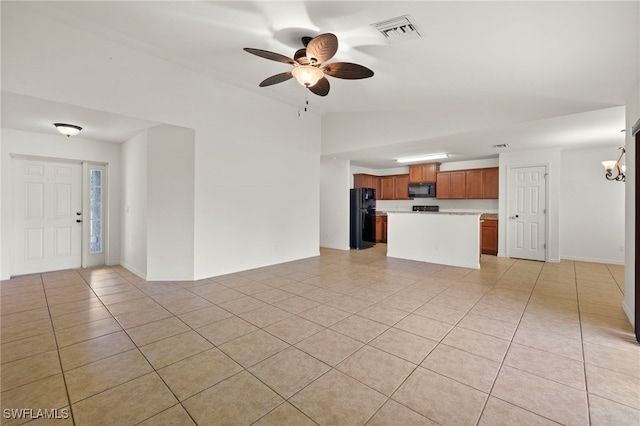 unfurnished living room with ceiling fan, light tile patterned floors, and vaulted ceiling