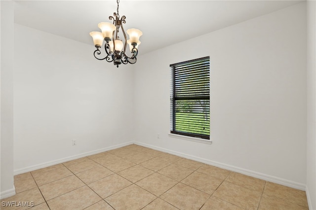 tiled empty room with a chandelier