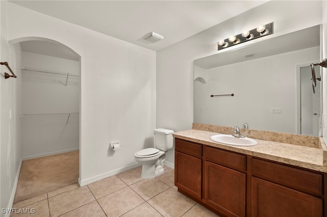 bathroom with tile patterned flooring, vanity, and toilet