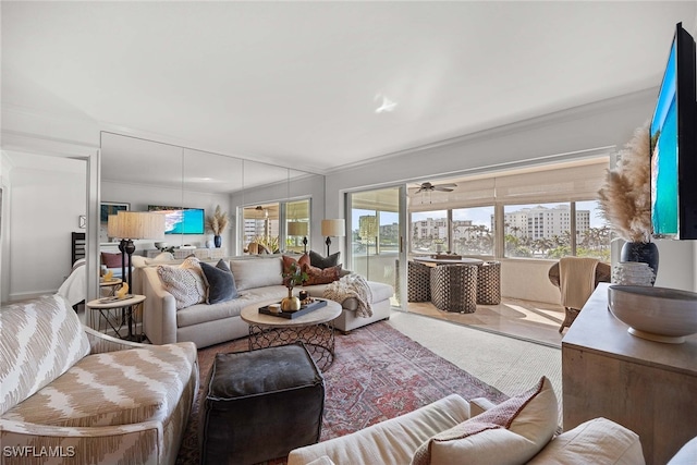 living room featuring carpet, ceiling fan, and crown molding