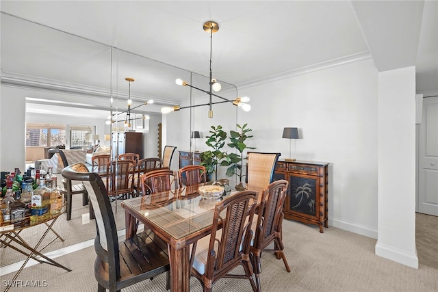 dining room featuring light carpet, a chandelier, and ornamental molding