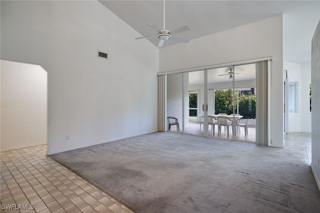 unfurnished living room with light colored carpet, high vaulted ceiling, and ceiling fan