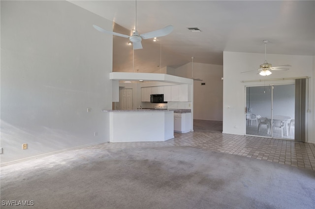 unfurnished living room featuring carpet, high vaulted ceiling, and ceiling fan