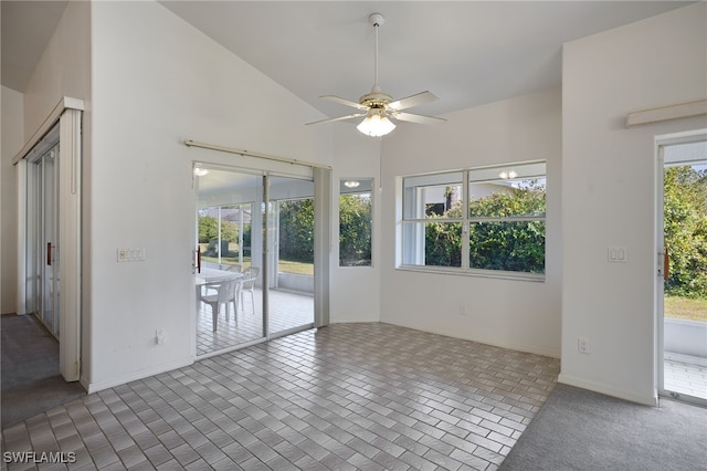 carpeted empty room with high vaulted ceiling, plenty of natural light, and ceiling fan