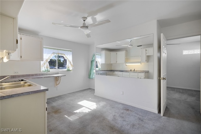 kitchen with white cabinetry, sink, ceiling fan, and light colored carpet