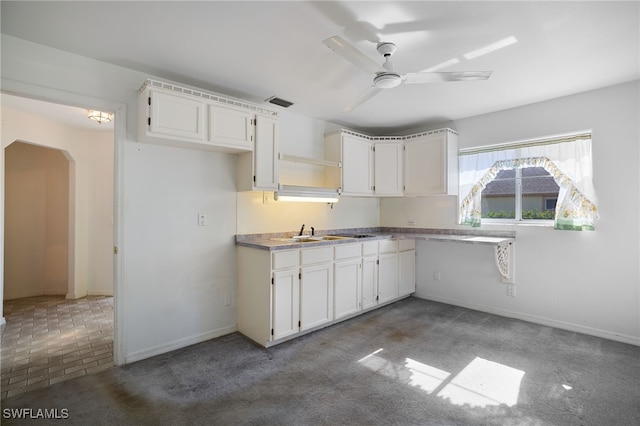 kitchen with carpet flooring, white cabinetry, ceiling fan, and sink