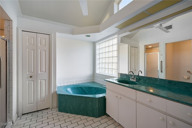 bathroom with tile patterned flooring, vanity, independent shower and bath, and vaulted ceiling