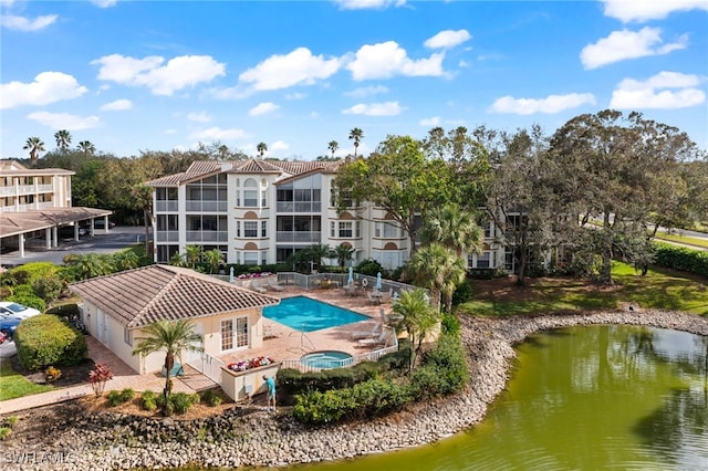 view of pool featuring a water view, an in ground hot tub, and a patio