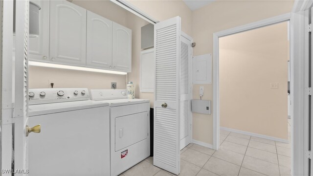 laundry area with cabinets, washing machine and clothes dryer, and light tile patterned flooring