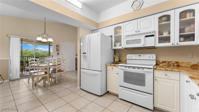 kitchen featuring light stone countertops, white appliances, hanging light fixtures, and light tile patterned floors