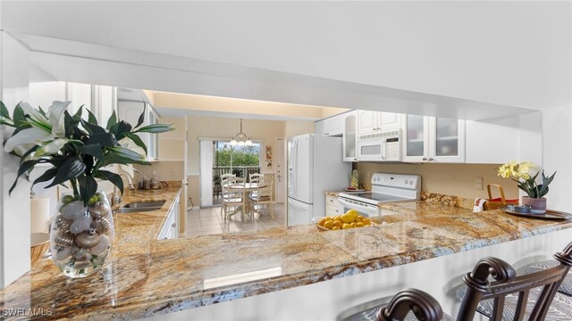 kitchen featuring white cabinetry, sink, hanging light fixtures, kitchen peninsula, and white appliances