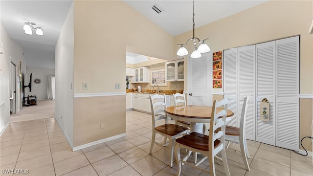 dining room featuring an inviting chandelier, lofted ceiling, and light tile patterned floors