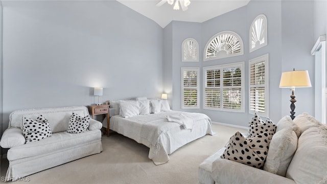 carpeted bedroom featuring ceiling fan and high vaulted ceiling