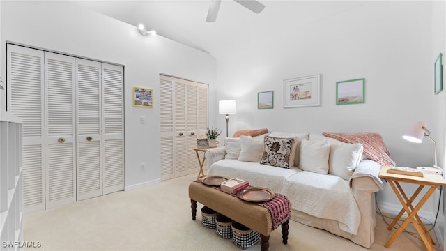 living room featuring ceiling fan, light colored carpet, and vaulted ceiling